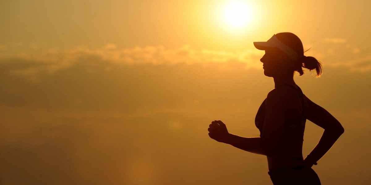 woman with white sunvisor running