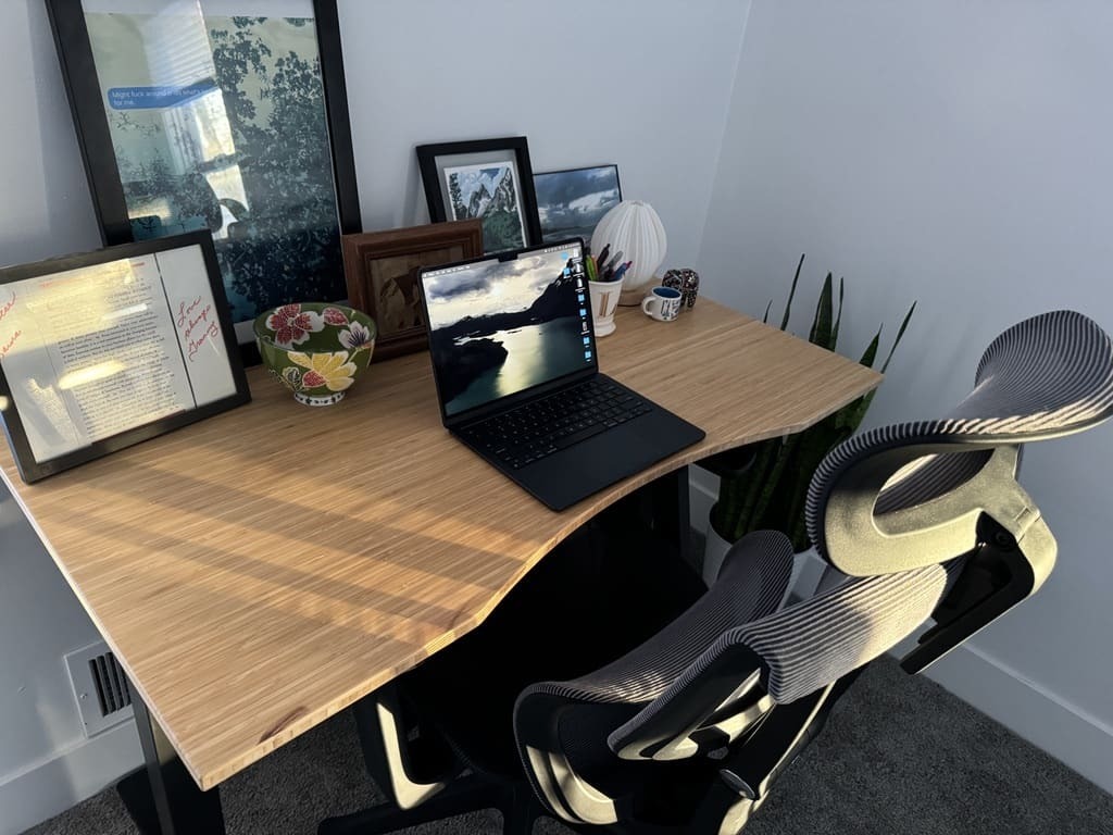 a desk with a laptop computer sitting on top of a table