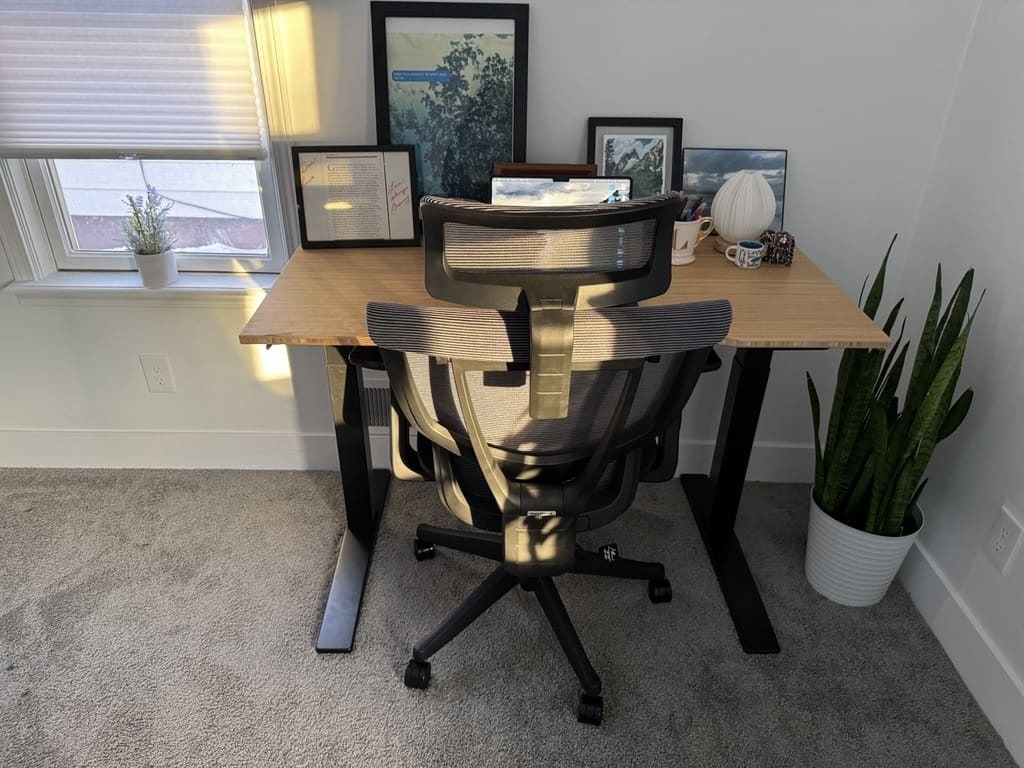 a desk with a computer and a chair in a room