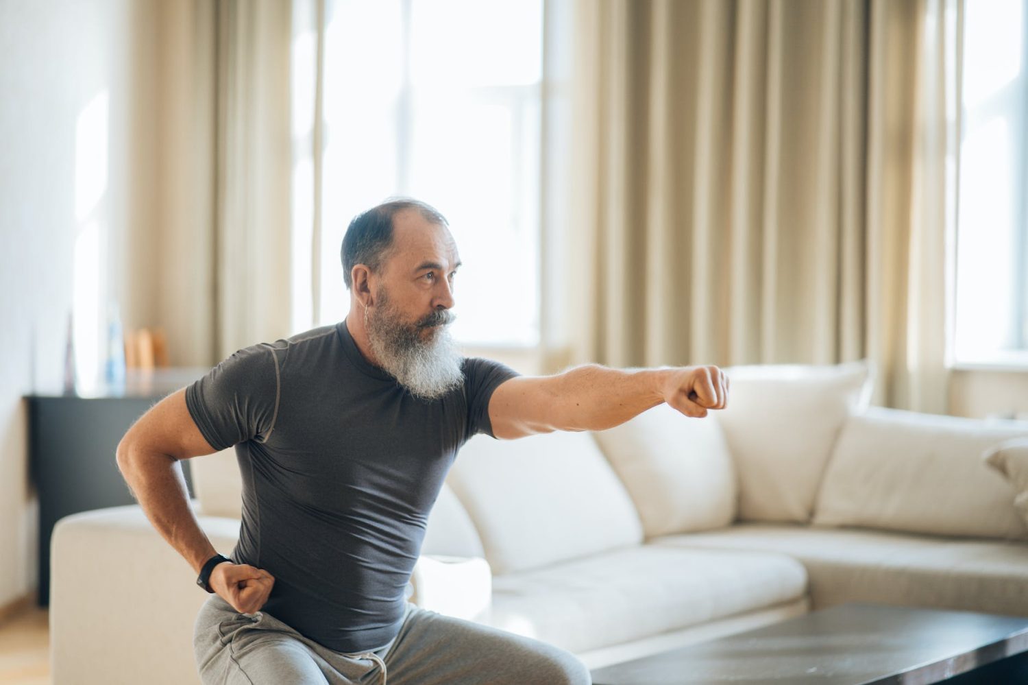 a man in black crew neck t shirt and gray pants doing an exercise