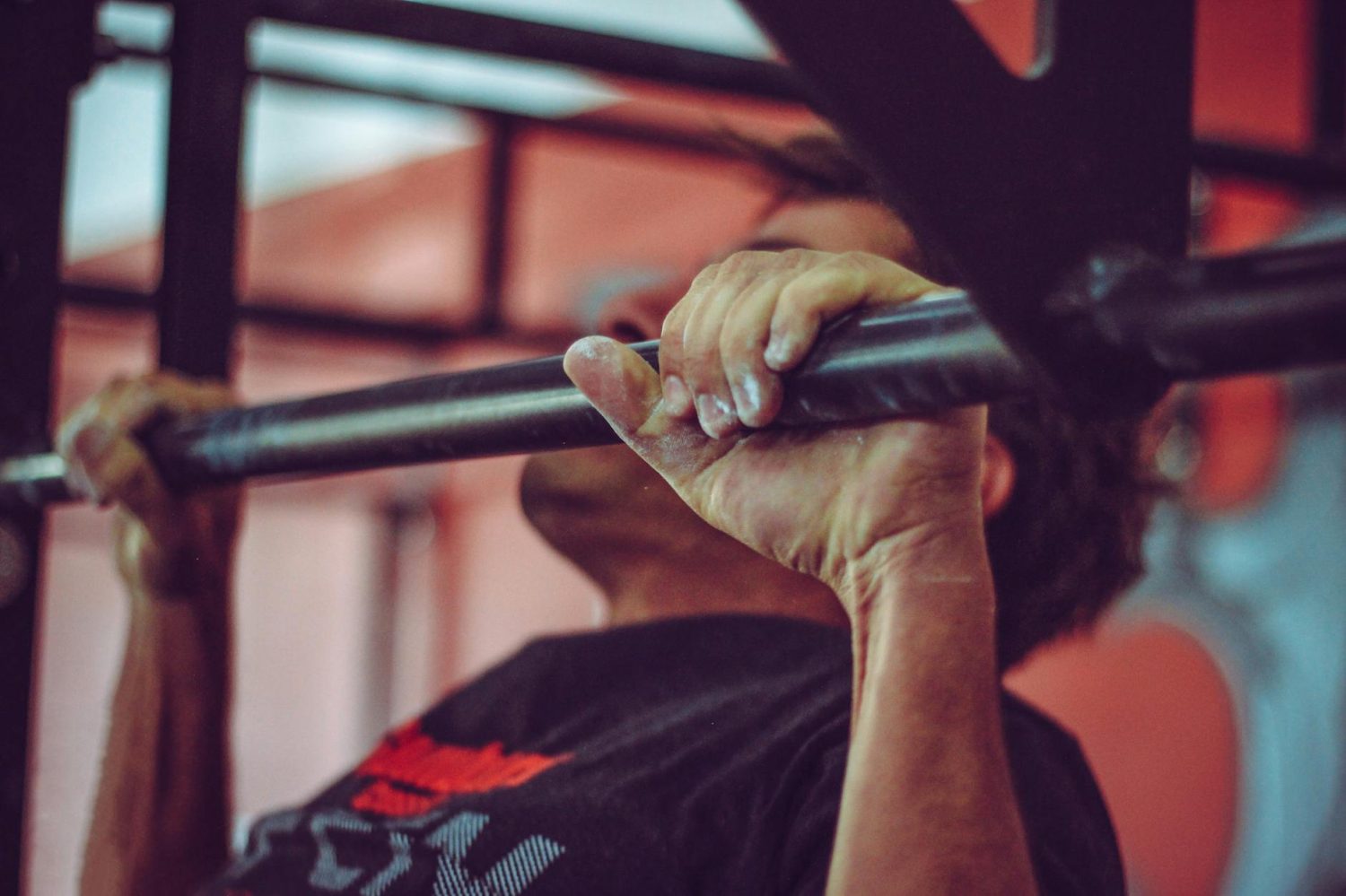 man in black crew neck shirt doing pull ups