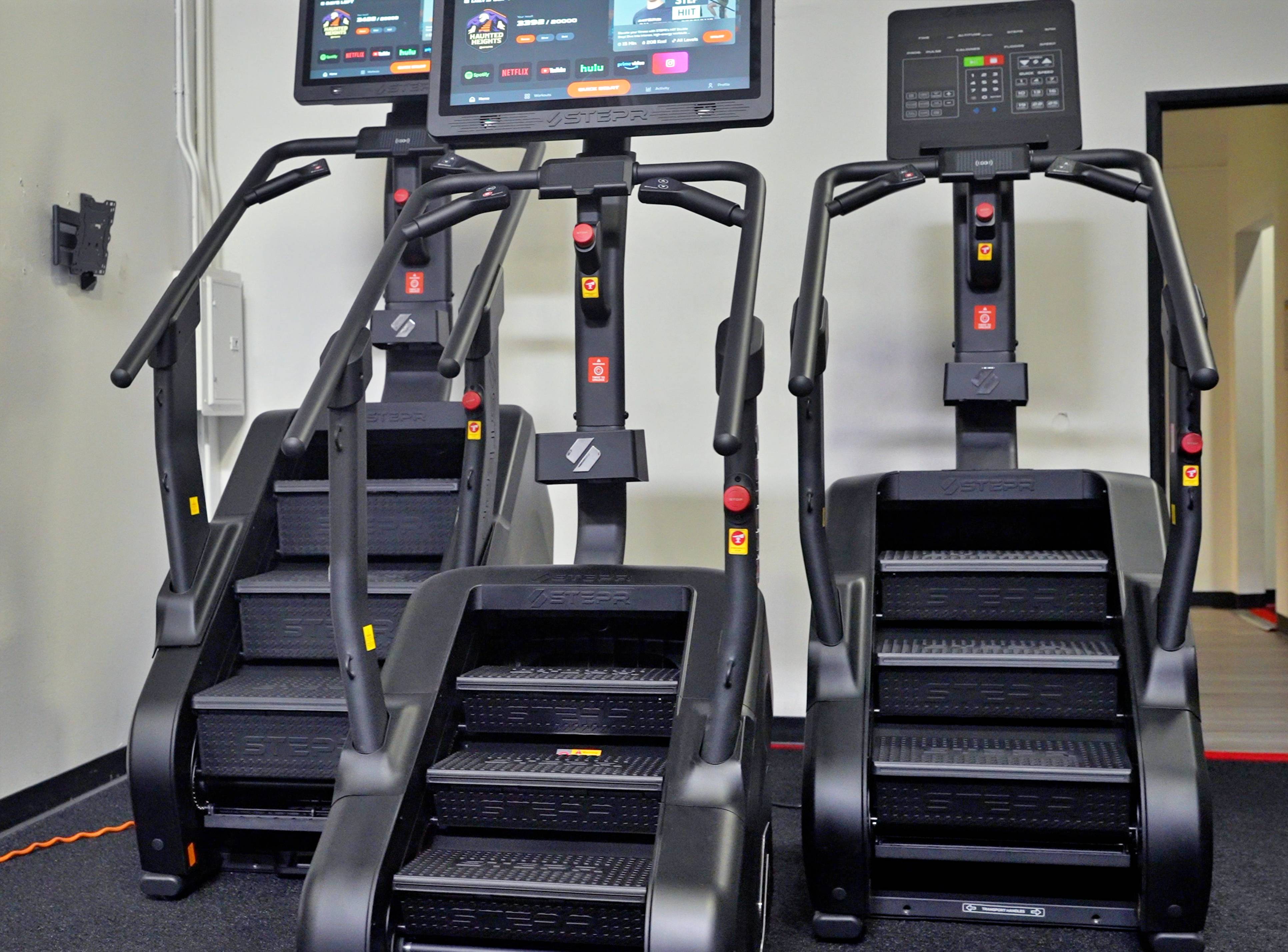 A group of treadmills with screens